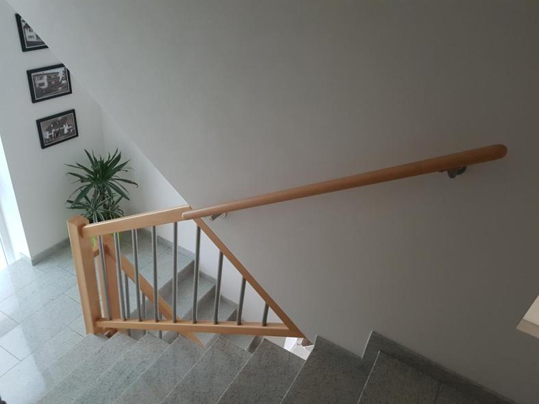 Steintreppe mit Holzgeländer mit Stahlstangen 